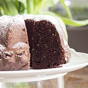 Angeschnittener Schokoladen-Gugelhupf mit gehackten Pistazien